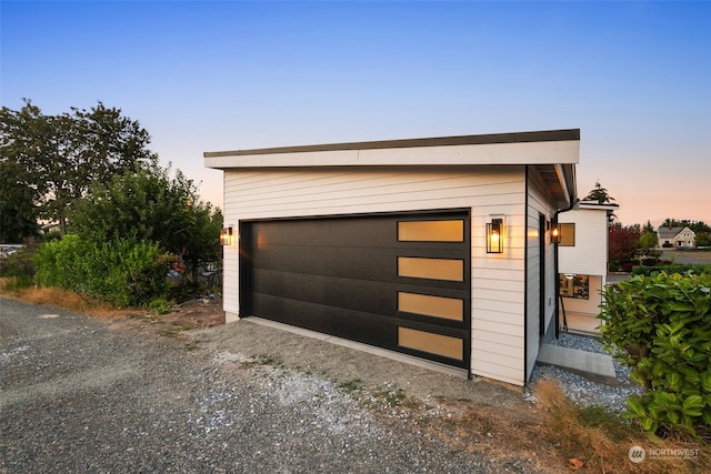 view of garage at dusk