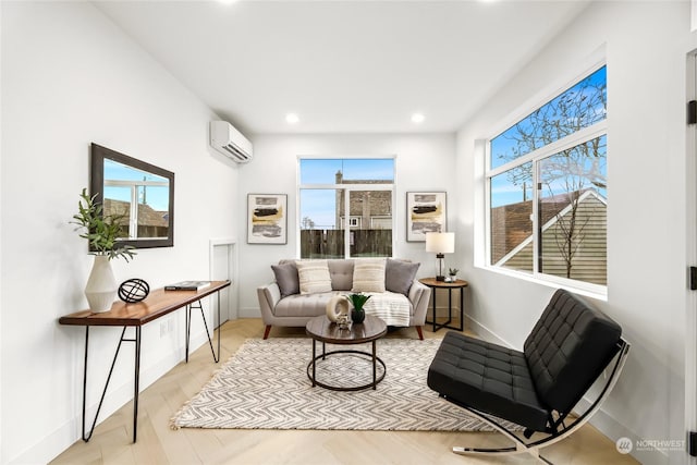 sitting room with light wood-type flooring, a wall unit AC, and a wealth of natural light