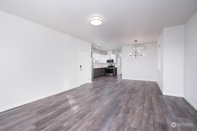 unfurnished living room featuring dark wood-type flooring and a chandelier