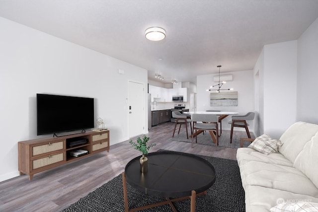 living room with sink, an inviting chandelier, and light wood-type flooring