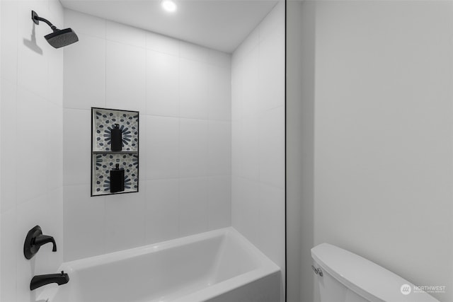 bathroom featuring tiled shower / bath combo and toilet