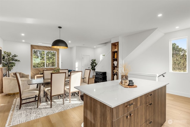 kitchen featuring a kitchen island, pendant lighting, and light wood-type flooring