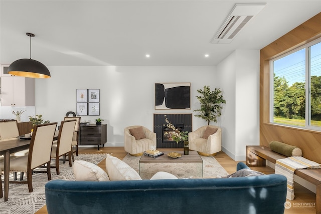 living room featuring light wood-type flooring and wood walls