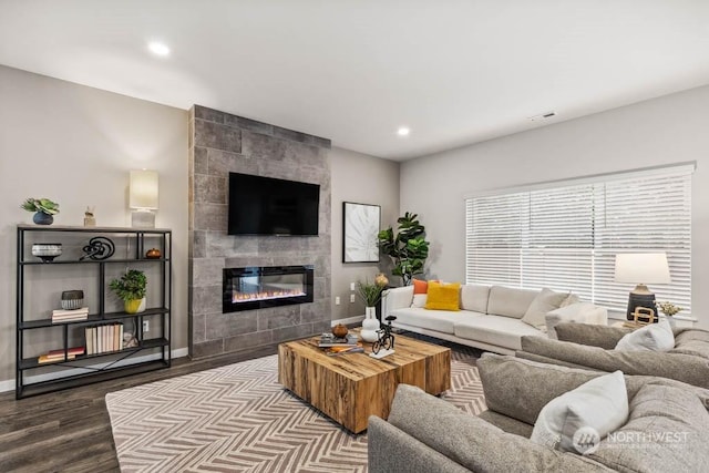 living room featuring wood-type flooring and a tile fireplace