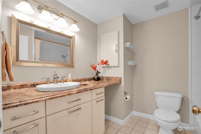 bathroom featuring tile patterned floors, vanity, and toilet