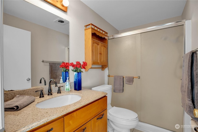 bathroom featuring vanity, toilet, and an enclosed shower