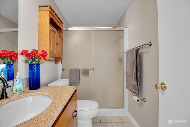 bathroom with tile patterned flooring, toilet, vanity, and walk in shower