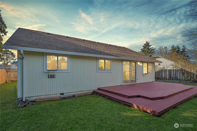 back of property featuring a wooden deck and a yard