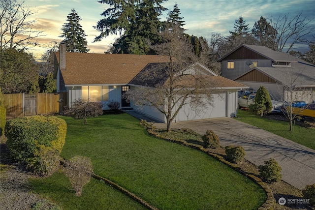 ranch-style house with a garage and a lawn