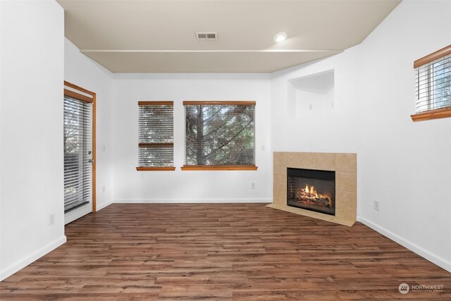 unfurnished living room featuring hardwood / wood-style flooring, a healthy amount of sunlight, and a fireplace