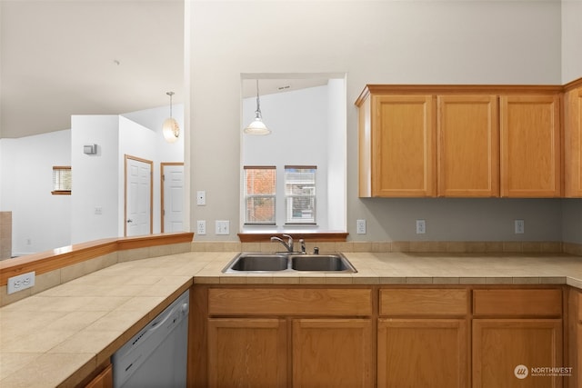 kitchen featuring pendant lighting, sink, white dishwasher, tile counters, and vaulted ceiling