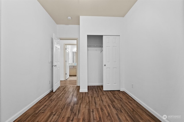 unfurnished bedroom featuring dark wood-type flooring and a closet