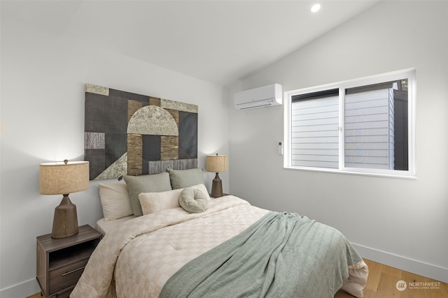 bedroom with lofted ceiling, hardwood / wood-style floors, and a wall unit AC