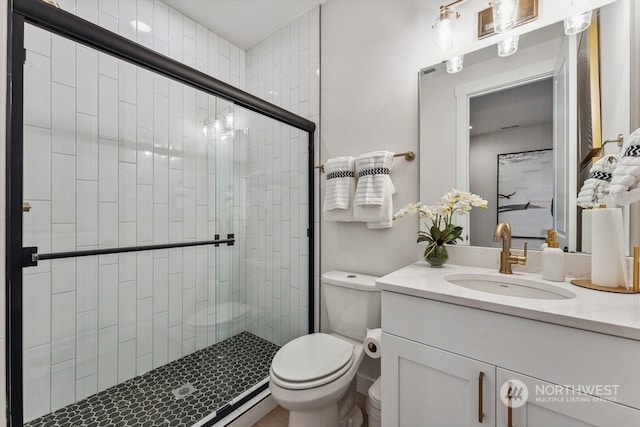 bathroom with vanity, a shower with shower door, and toilet