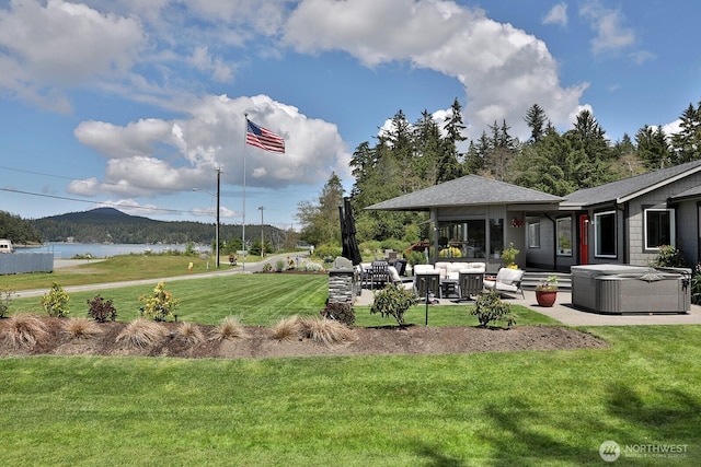 view of yard featuring a patio area, a water view, and a hot tub