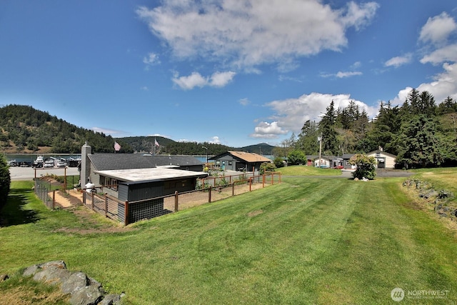 view of yard with an outbuilding, a mountain view, and fence