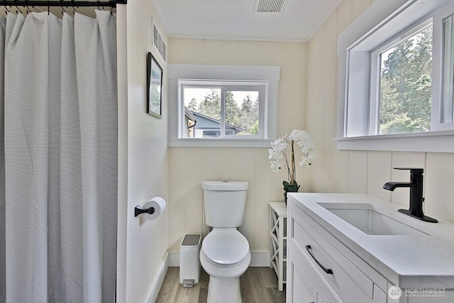 full bath with visible vents, toilet, curtained shower, wood finished floors, and vanity