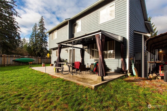 back of property with a patio and a yard