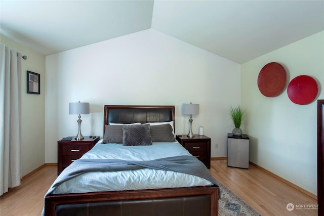 bedroom featuring lofted ceiling and light hardwood / wood-style floors