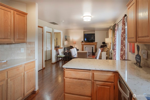 kitchen with dark hardwood / wood-style flooring, backsplash, a fireplace, and light stone countertops