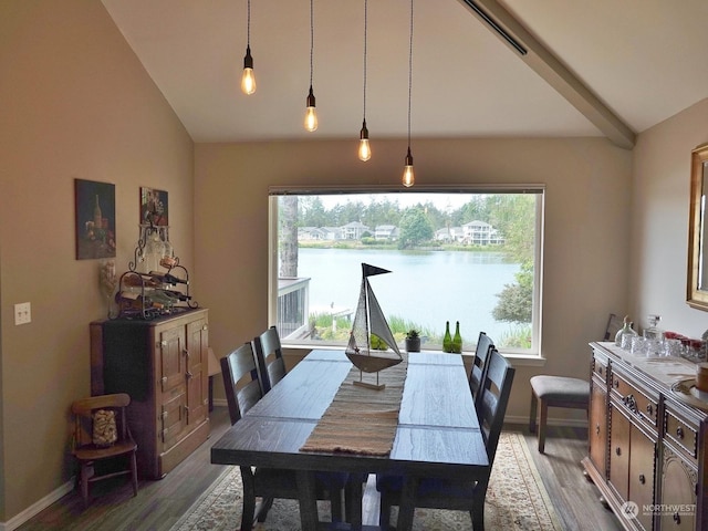 dining space with a water view, wood-type flooring, and lofted ceiling with beams