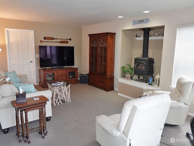 living room with light carpet and a wood stove