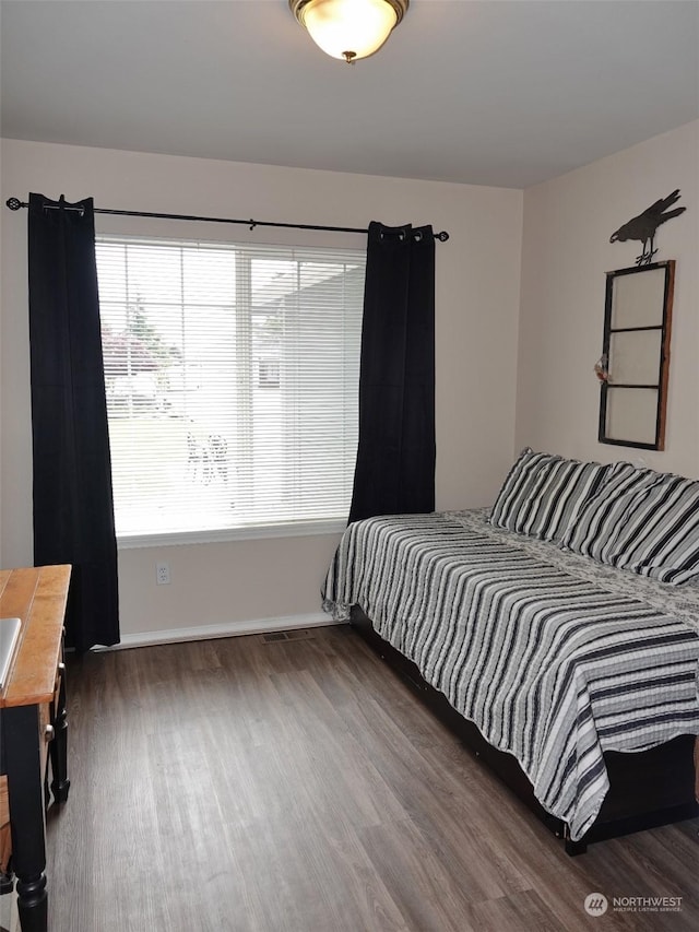 bedroom with dark hardwood / wood-style flooring