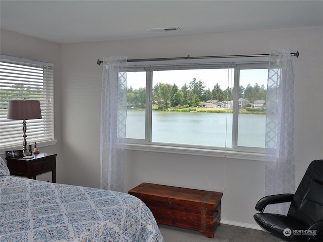 bedroom featuring a water view and carpet flooring