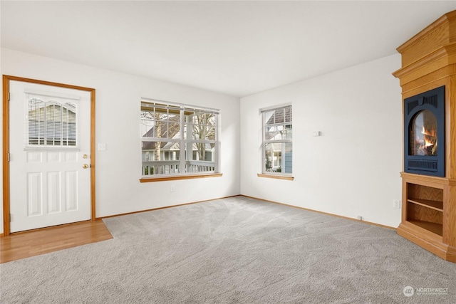 unfurnished living room featuring a fireplace and carpet floors