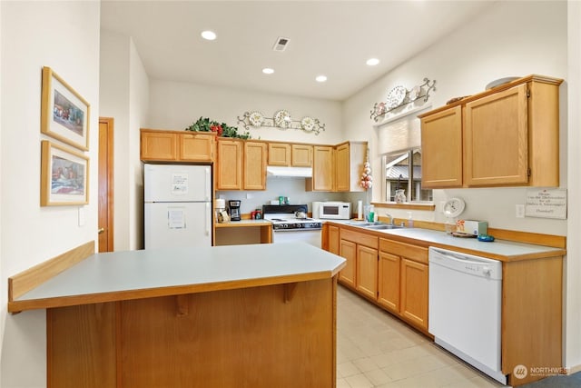 kitchen with sink, white appliances, and light brown cabinets