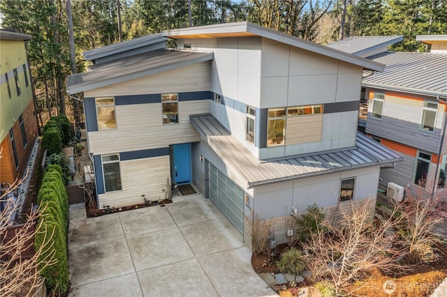 modern home featuring a standing seam roof, metal roof, and stucco siding