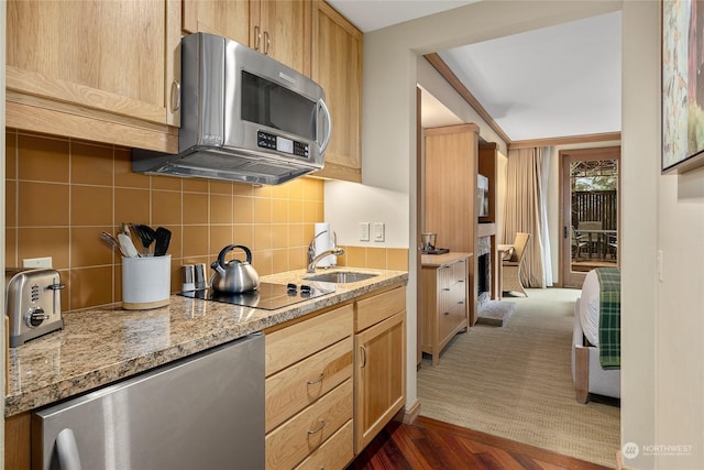 kitchen featuring dark wood-type flooring, sink, light brown cabinets, black electric stovetop, and decorative backsplash