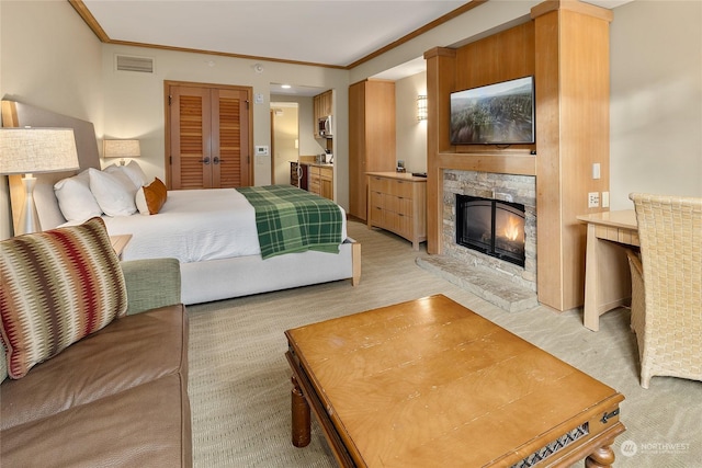 carpeted bedroom with crown molding, a fireplace, and a closet