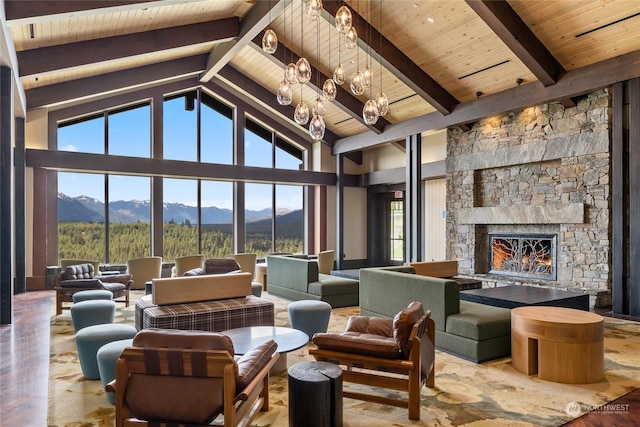 living room with a notable chandelier, a fireplace, a mountain view, wooden ceiling, and beamed ceiling