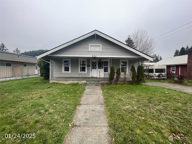 bungalow with a porch and a front lawn