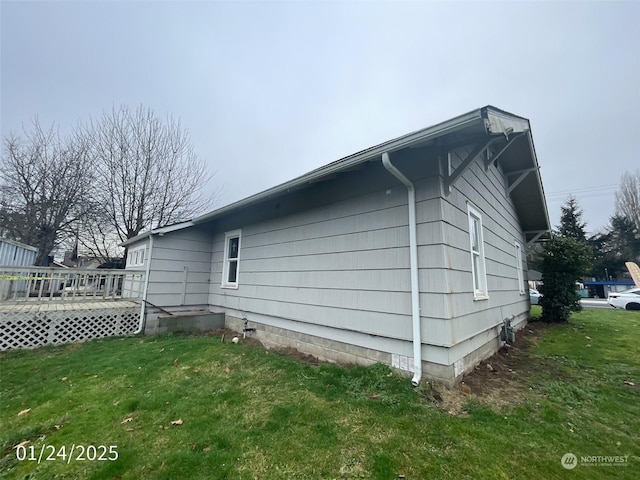 view of side of property with a deck and a lawn