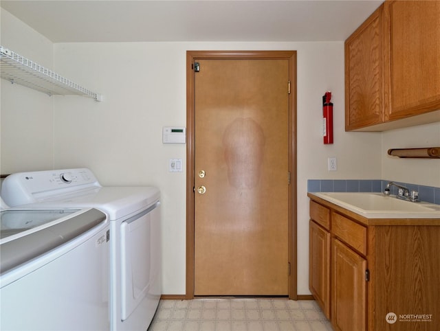 laundry area featuring cabinets, washing machine and dryer, and sink