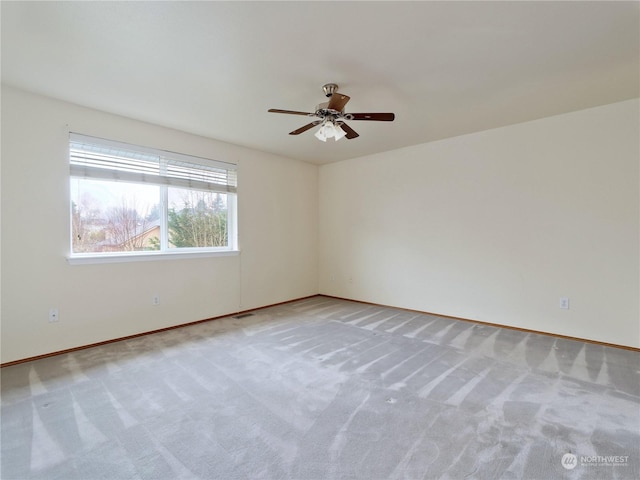 carpeted empty room featuring ceiling fan