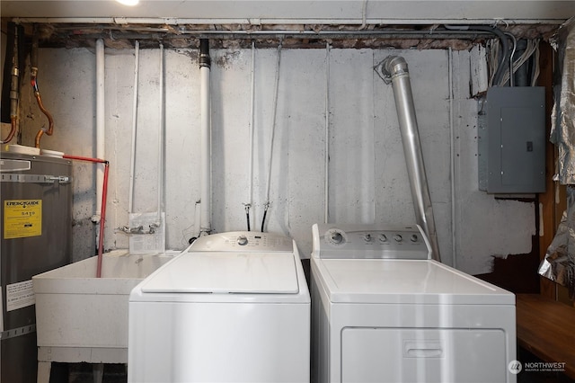 washroom featuring sink, strapped water heater, electric panel, and washer and clothes dryer