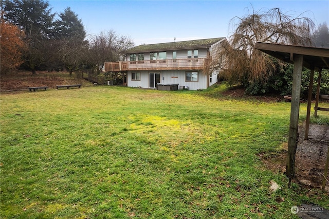 rear view of house with a lawn and a deck