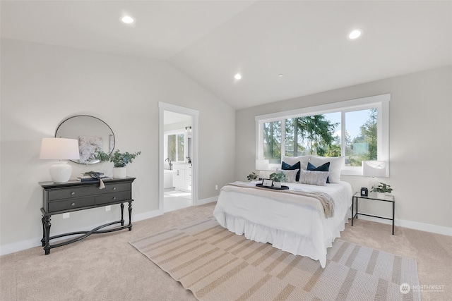 bedroom featuring lofted ceiling, ensuite bathroom, and light carpet