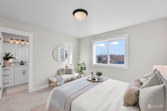 bedroom with sink, light colored carpet, and ensuite bath