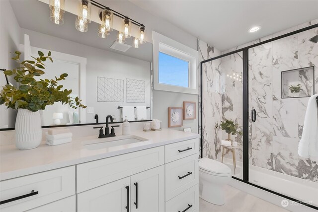 bathroom with vanity, toilet, and a shower with door