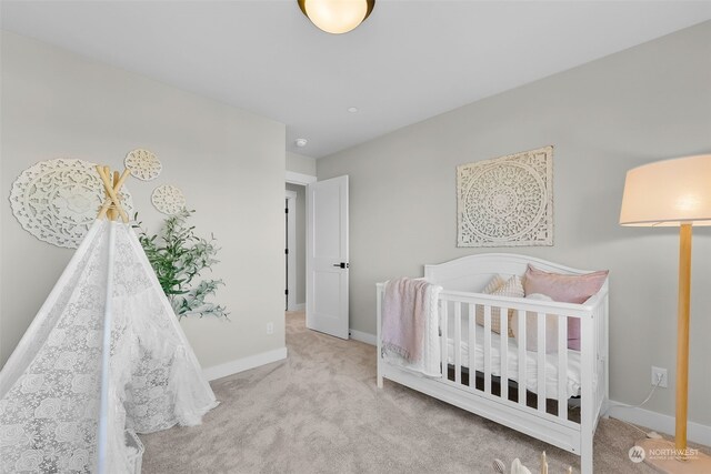 bedroom with a nursery area and light colored carpet