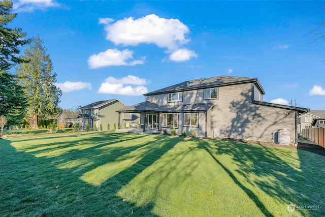 rear view of property with a yard and a patio area