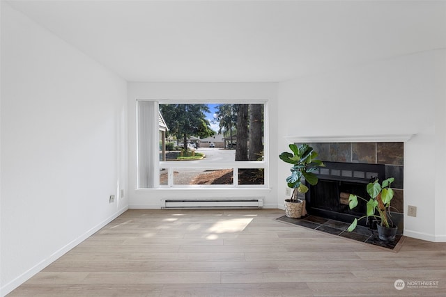 living room featuring a baseboard radiator, a fireplace, and light hardwood / wood-style flooring