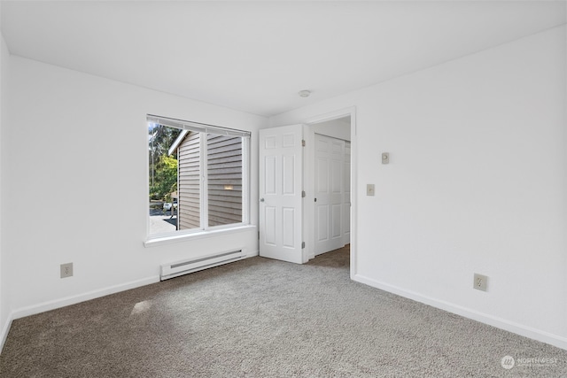 carpeted empty room featuring baseboard heating