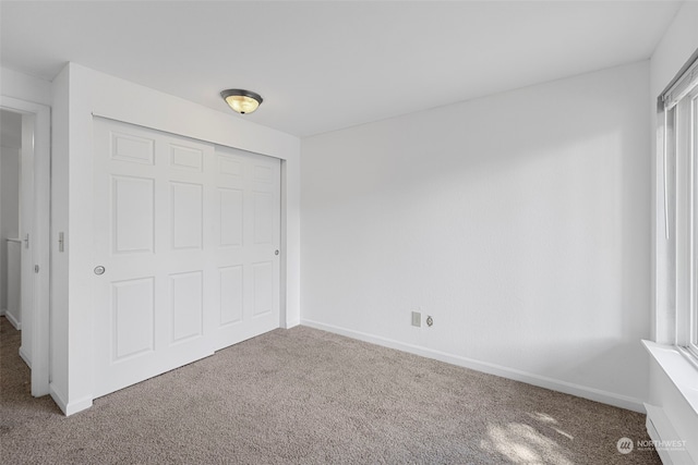 unfurnished bedroom with carpet flooring and a closet