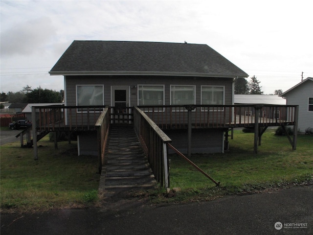 view of front of home with a wooden deck and a front lawn