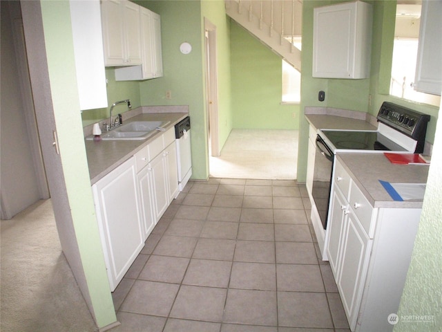 kitchen featuring sink, white cabinetry, light tile patterned floors, plenty of natural light, and white appliances